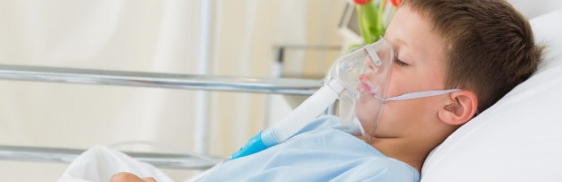 Niño enfermo en cama hospitalaria con respirador